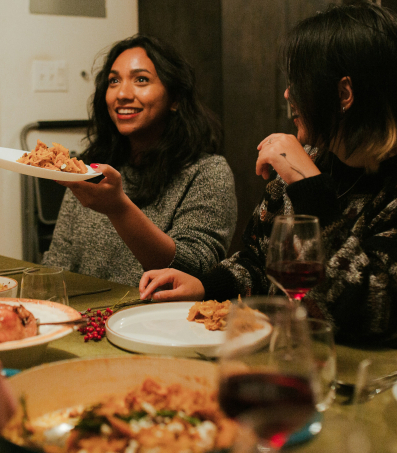 Mensen rondom een tafel eten Italiaans eten.