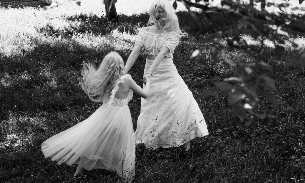 Twee meisjes met albinisme dansen in witte jurken.