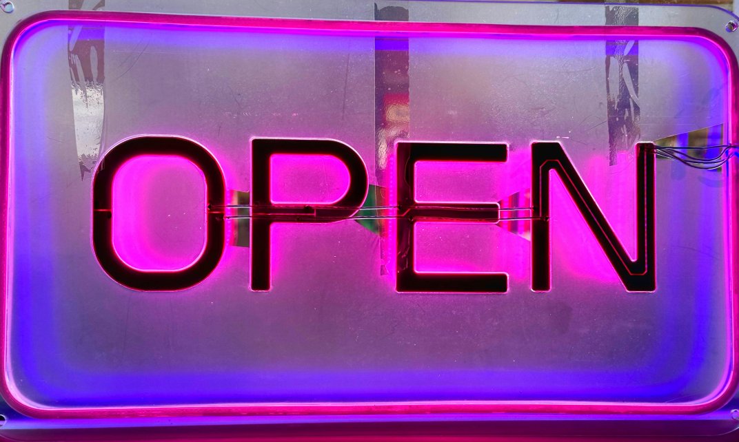 Een neon bord met de tekst 'Open'