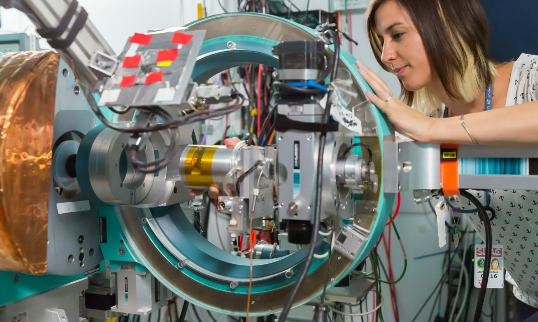 Een onderzoeker past een machine aan in een laboratoriumopstelling.